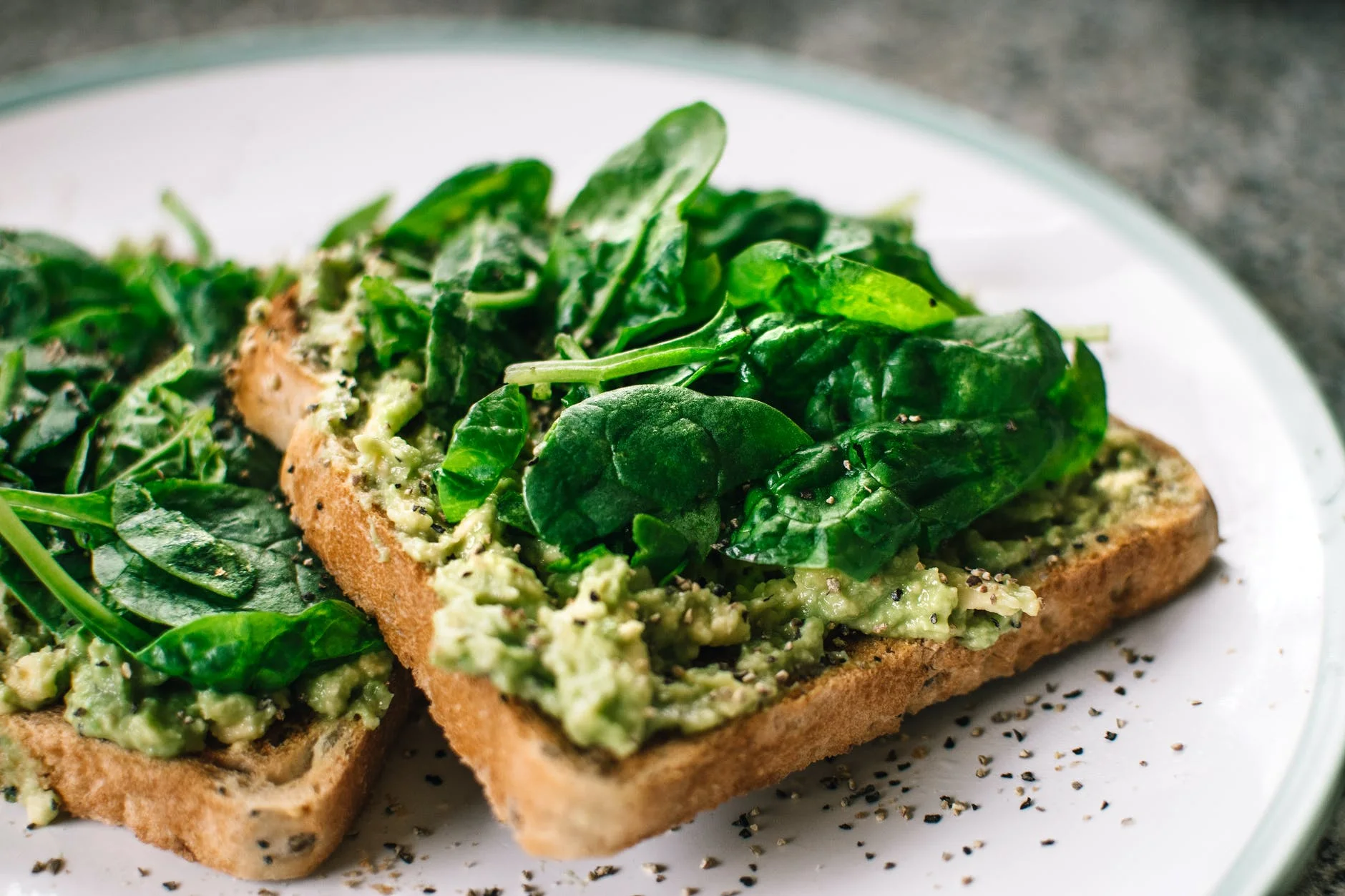 ŞİRKETLERE DİYET MENÜ 1 basil leaves and avocado on sliced bread on white ceramic plate